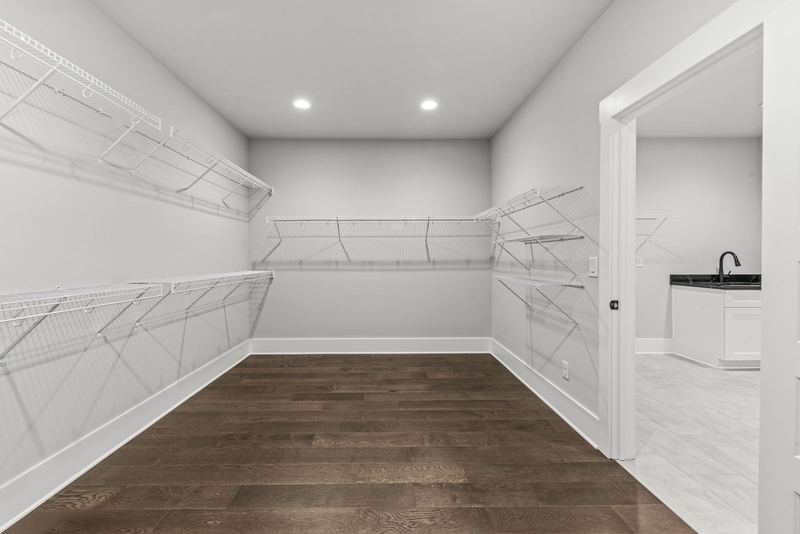 Primary walk-in closet with built-in shelving