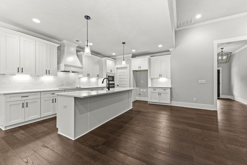 Kitchen with vent hood, island and tile backsplash