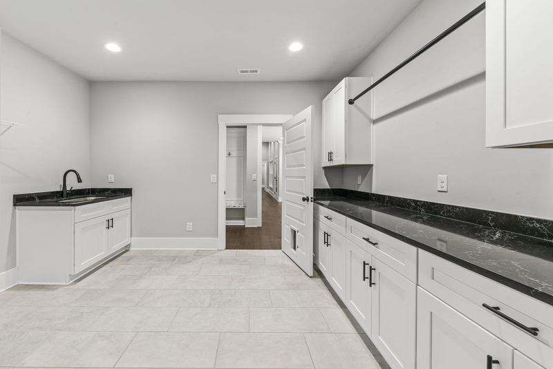 Oversized laundry room with cabinetry and counters